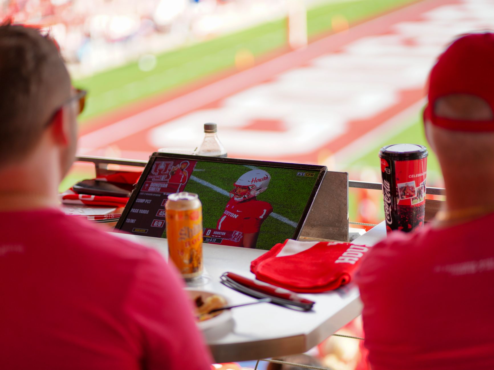 Torcedores acompanham jogo de futebol em um tablet no estádio