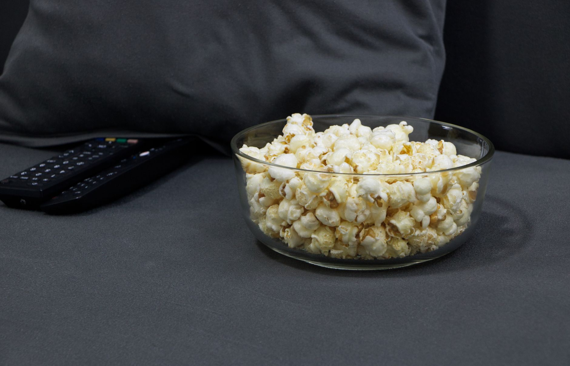 Sessão de streaming após mudança nos preços da Netflix Pipoca e controles remotos preparados para assistir streaming