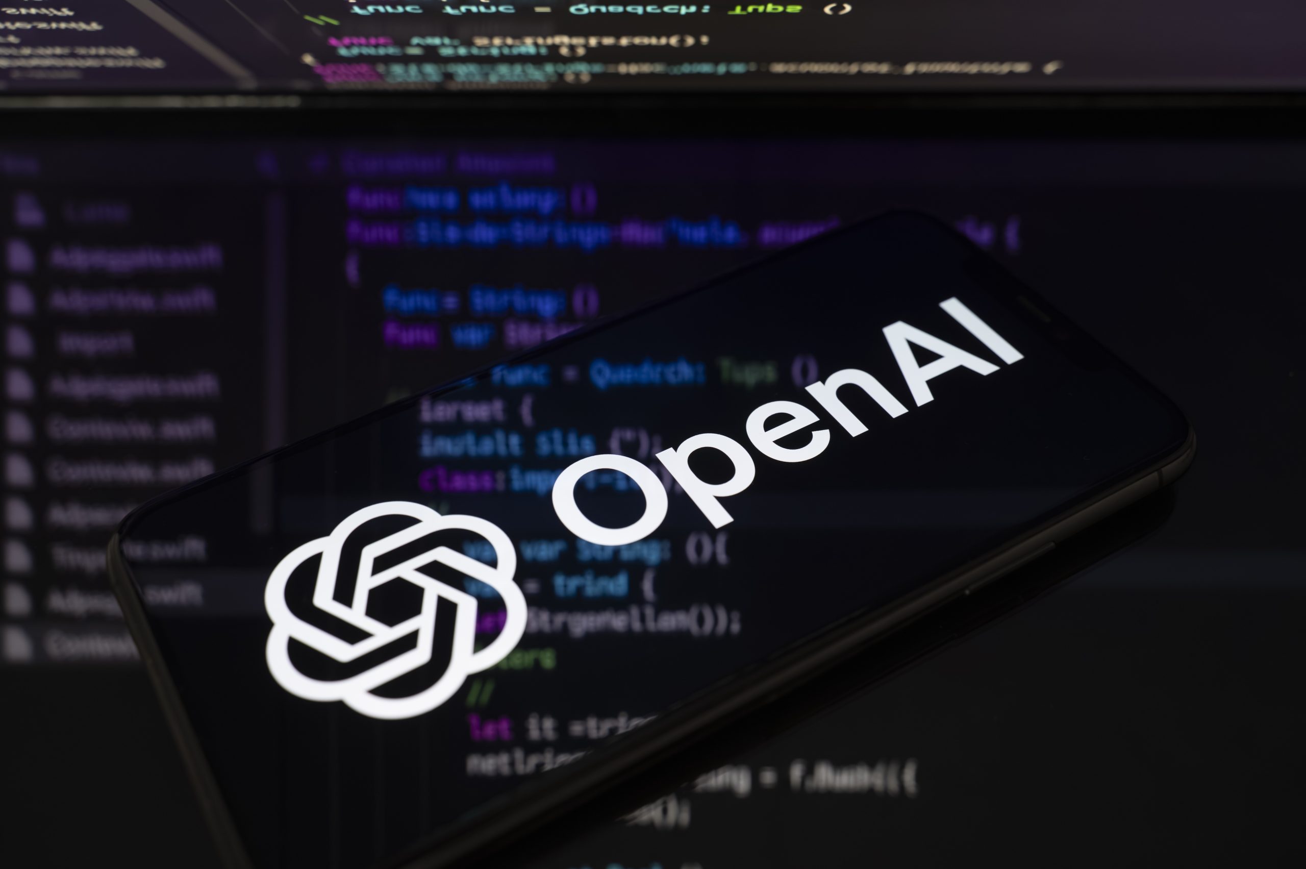 segurança da OpenAI com logotipo em smartphone sobre código
